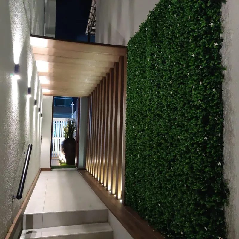 Corredor externo com deck, pergolado e jardim vertical